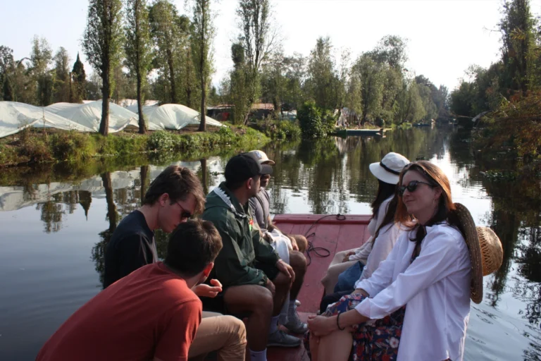 Grupo realizando recorrido por el humedal de Xochimilco en trajinera durante visita a barrios antiguos